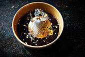 Baked Alaska with chocolate sauce and gold leaf