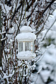 Weiße Laterne im schneebedeckten Garten