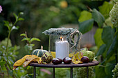 Windlicht mit Herz aus Heide auf herbstlich dekoriertem Tisch im Garten