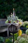 Planter decorated in autumn with heather, hydrangea flowers and candles