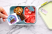 Healthy lunchbox with watermelon and muesli bar