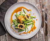 Bacon dumplings filled with dried plums on green beans