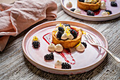 Blackberry tart with whipped cream and lemon zest
