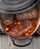Beef roulades on a bed of vegetables in a casserole