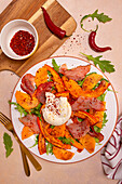 Rocket salad with baked pumpkin, Italian ham, burrata and chilli