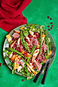 Salad with halloumi, green asparagus, pear, ham and pomegranate