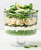 Layered pasta salad with spinach, peas and asparagus