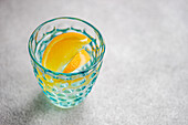 Wasserglas mit Orangenscheiben und Eiswürfeln