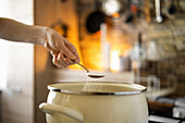 Sprinkling a spoonful of salt in a pot