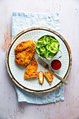 Wiener schnitzel with cucumber salad and ketchup