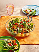 Bread salad with spinach, chard, cherry tomatoes and zucchinis