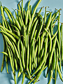 Fresh green beans on a light blue background