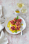 Rose ravioli with eggplant and goat's cheese filling on saffron sauce