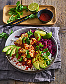 Tofu bowl with red cabbage, avocado and sriracha