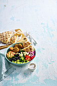 Falafel salad with vegetables, hummus, olives and flatbread