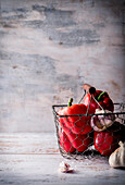 Red peppers and garlic in a wire basket