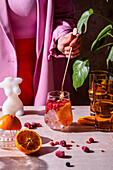 Summer cocktail with raspberries and orange slices on ice