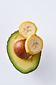 Sliced avocado with stone and ripe banana