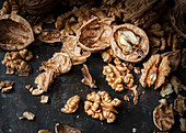 Whole and cracked walnuts on a dark background