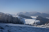 Winterlandschaft mit verschneiten Hügeln und Wäldern im Aargau, Schweiz