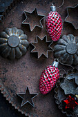 Old biscuit tins and red cone Christmas decorations on a baking tray