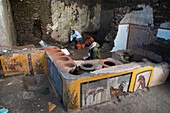 Archaeologists excavating ancient Roman food stand, Pompeii, Italy