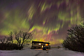 Auroral rays over rural house