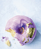 Purple mirror glaze donut with edible gold leaf