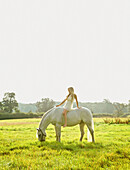 Young Woman Riding Horse in Field