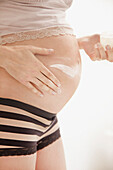 Pregnant Woman Applying Beauty Cream on her Stomach