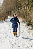 Frau beim Wandern auf schneebedecktem Feld