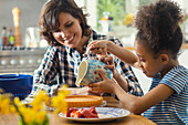 Mutter und Tochter beim Backen eines Kuchens