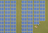 View from above engineers assembling solar panels on solar farm