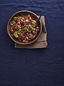 Still life view from above healthy spelt salad with radicchio and vegetables on blue tablecloth