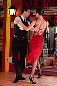 An attractive young couple dances the tango on El Caminito in the La Boca barrio of Buenos Aires, Argentina.