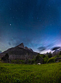 A vertical panorama of the moonlit spring sky with the Big Dipper and Arcturus over the jagged outline of Anderson Peak at the Red Rock Canyon area of Waterton Lakes National Park, Alberta, a UNESCO World Heritage site and Dark Sky Preserve.