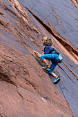 Ein 6-jähriger Junge lernt im Hunter Canyon in der Nähe von Moab, Utah, das Klettern.