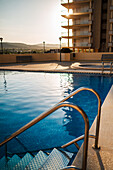 Pool in einer privaten Wohnanlage in Peñiscola bei Sonnenuntergang, Castellon, Valencianische Gemeinschaft, Spanien