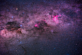 This frames the spectacular region of the southern Milky Way, indeed the southernmost portion of the Milky Way, through Crux (at left) and Carina (at right). Below Crux are the stars of Musca the Fly, framed to include the Dark Doodad nebula, the long streak of dark dust below the larger Coal Sack nebula beside the stars of Crux, the Southern Cross. The large bright Carina Nebula at right is surrounded by a variety of star clusters, including the blue Southern Pleiades, IC 2602, at lower right. At centre is the Running Chicken Nebula, IC 2944/48.