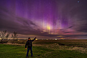 A selfie of me at the start of the great aurora show of May 10, 2024, with the aurora curtains still in the early evening twilight sky and looking very purple. Despite the clouds about.