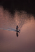 Standup paddleboarding at sunset in Ebro River, Zaragoza, Spain