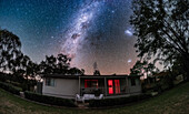 This is the southern Milky Way in Carina, Crux and Centaurus arcing over Mirrabook Cottage near Coonabarabran, NSW, Australia. At right are the Large and Small Magellanic Clouds. This is looking south to the South Celestial Pole which is near centre here.