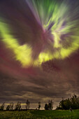 An outburst of a substorm during the great May 10, 2024 display of Northern Lights, here creating an overhead corona with rays converging to the magnetic zenith (south of the true zenith), and amid clouds. Arcturus is below the zenith. The constellation of Corona Borealis (fittingly!) is left of the convergence point.