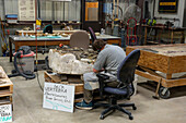 A paleontologist chips away the rock from a neck vertebra of a Barosaurus in the BYU Paleontology Museum in Provo, Utah.