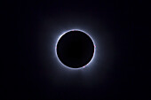 This is the total eclipse of the Sun of April 8, 2024, in a blend of two exposures to display all the fiery pink prominences that were visible during totality around the lunar disk in one image, set against the bright inner corona of the Sun with the dark disk of the Moon in silhouette in front of the Sun.