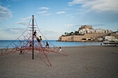 Kinderspielplatz am Strand und die Burg von Papa Luna in Peñiscola, Castellon, Valencianische Gemeinschaft, Spanien