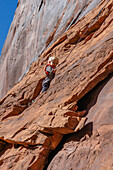 Ein kleiner Junge, 3 Jahre alt, lernt im Hunter Canyon in der Nähe von Moab, Utah, das Klettern.