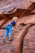 A young boy, age 6, learning to rock climb in Hunter Canyon near Moab, Utah.