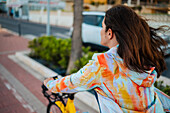 Frau fährt mit dem Fahrrad an der Promenade entlang, Peñiscola, Spanien