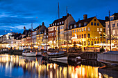 Colourful buildings and tall masted boats on the waterfront at Nyhavn at night, Nyhavn Canal, Nyhavn, Copenhagen, Denmark, Europe